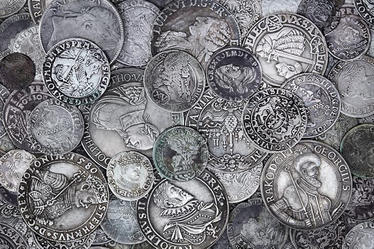 A pile of silver coins from around the world